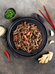 Asian teriyaki beef strips with spice, sesame on a gray background. Top view. Asian food.