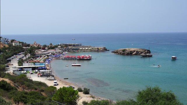 Kyrenia (Girne in Turkish), North Cyprus - July 13, 2025: Karaoglanoglu beach next to the Monument of freedom and peace (Ozgurluk ve Baris Aniti in Turkish)