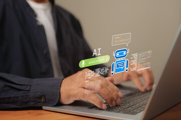Businessman typing on laptop with virtual AI chatbot assistant icon, digital technology and artificial intelligence concept for online customer support, automation, and communication innovation.