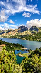 Obraz premium Panoramic view of a serene lake nestled amongst towering mountains under a vibrant blue sky filled with fluffy clouds.