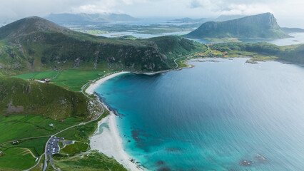 Breathtaking aerial perspective showcasing the dramatic Mannen mountain towering above the serene Haukland beach in Lofoten, Norway.