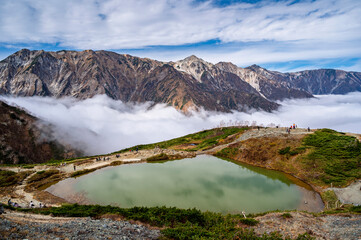 Hiking Route to Happo Pond and  the Japanese Alps mountains landscape with mist background on Hakuba Happo One in Hakuba, Nagano, Japan