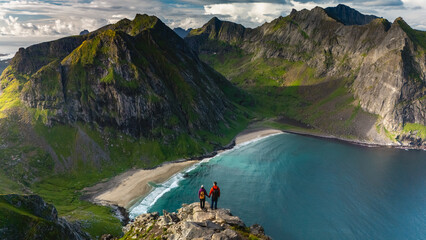 Adventurers enjoy panoramic views over the stunning Ryten Kvalvika Beach Trail in Lofoten, Norway.