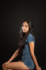 Naklejka premium Young woman posing in denim against black background with copy space