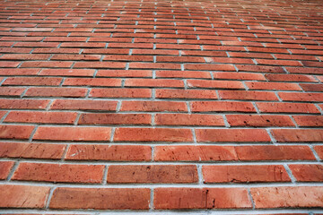 The texture of the red brick wall in a symmetrical arrangement seen from bottom to top    