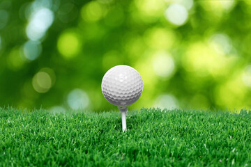 Golf ball on green grass against blurred background