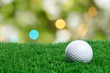 Golf ball on green grass against blurred background