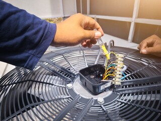 The electrician check and repair fan condensor motor on the chiller system. repair and maintenance concept for condensor chiller system.