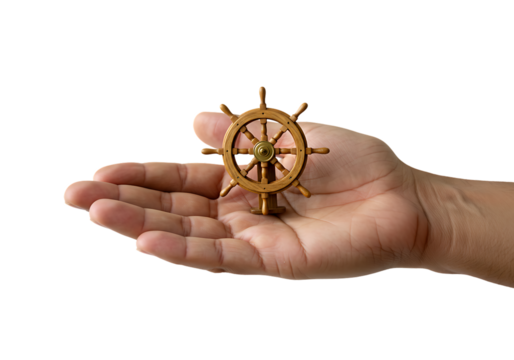 Hand holding a miniature wooden ship wheel on white backdrop, symbolizing control, guidance, and navigation in life's journey, creating a sense of direction.