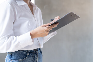 Asian inspector checking structure of new property and taking note in the clipboard for review and fix the house before sell to client