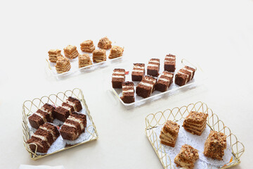 Sliced pieces of assorted cakes on festive trays prepared for guest serving.