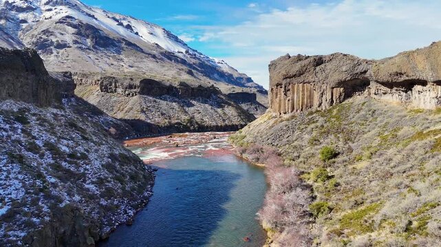 Panoramic aerial fly from striking Salto del Agrio waterfall plunging into the river bay in a rocky Patagonian volcanic canyon, Neuquén, Argentina.