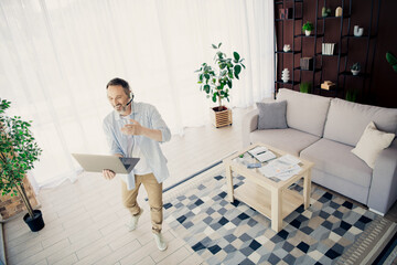 Confident business professional working from home using a laptop, engaging in a virtual meeting in a stylish setting