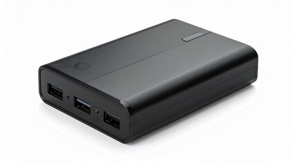 Fototapeta premium A matte black external hard drive dock with USB ports rests on a light surface—its clean lines and utilitarian form evoke digital order, expandable memory, and the quiet infrastructure of data.