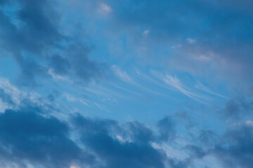 Blue sky before twilight with various cirrus clouds close-up.