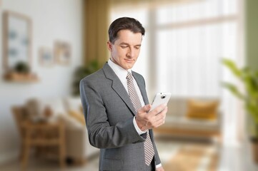Fototapeta premium Smiling happy business man holding mobile phone