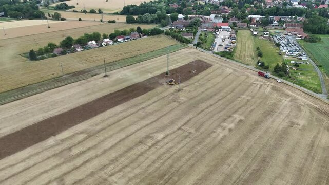 Aerial drone footage of a combine harvester cutting a golden wheat field, showcasing modern agriculture, grain harvest, rural landscape, and seasonal farming productivity.