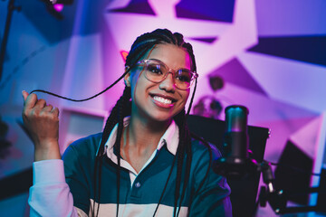 Radio host broadcasting from home with professional microphone setup and vibrant lighting in a cozy modern setting