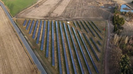 Aerial drone footage of a solar farm with rows of photovoltaic panels, highlighting clean energy production, high efficiency, and modern renewable power infrastructure.
