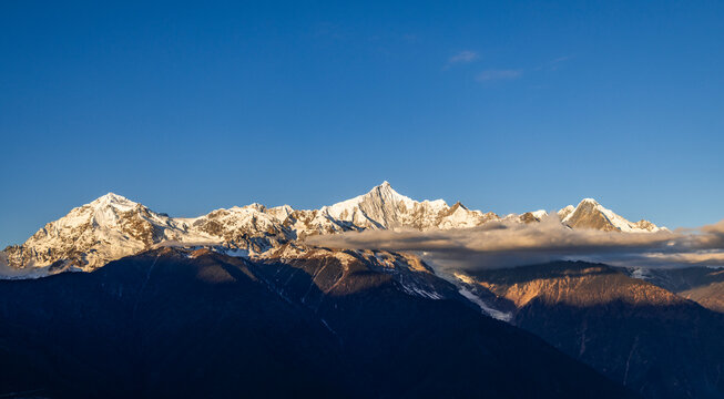 Aerial view of the Golden Mountain bathed in sunlight on Meili Snow Mountain in Yunnan Province - Powered by Adobe