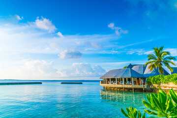 Beautiful water villas in tropical Maldives island at the sunrise time .