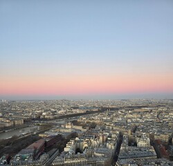 Obraz premium Panoramic city skyline at dusk with pastel sky and river