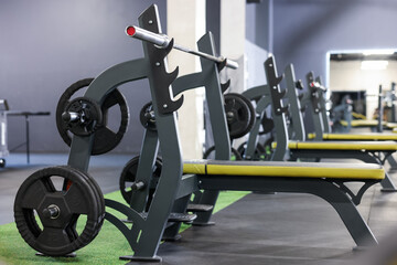 Obraz premium Weight benches with barbell and discs in gym