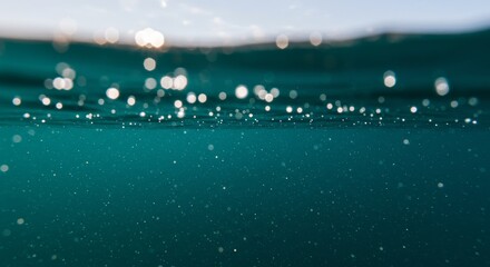 An underwater photo of deep water with glowing particles.