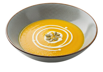 Isolated bowl of golden pumpkin soup swirled with cream and garnished with pumpkin seeds