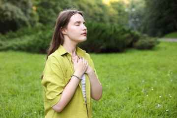 Woman meditating to heal or restore her aura in nature, space for text
