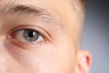 Fototapeta premium Man with beautiful eyes on light grey background, closeup