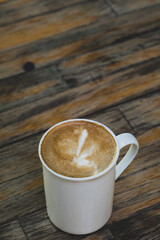 Latte in White Cup on Wooden Table. Cozy Latte Coffee Cup on Wooden Background. Morning Latte in Ceramic Mug on Wood Table.