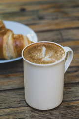 Latte Coffee and Croissant on Wooden Table. Cup of Latte and Croissant Morning Snack. Delicious Latte with Fresh Croissant on Table. Fresh Croissant with Cup of Latte.