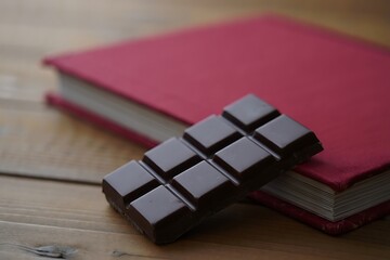 Dark chocolate bar resting on a red book