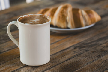 Latte Coffee and Croissant on Wooden Table. Cup of Latte and Croissant Morning Snack. Delicious Latte with Fresh Croissant on Table. Fresh Croissant with Cup of Latte.