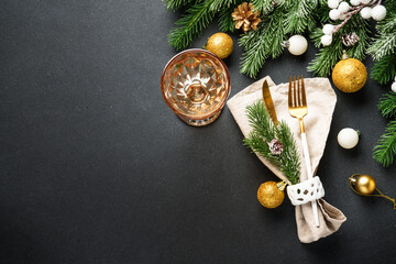 Modern golden cutlery and christmas decorations at black.