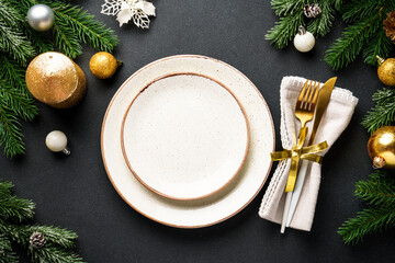 Christmas food background. Craft plate with golden christmas decorations at black.