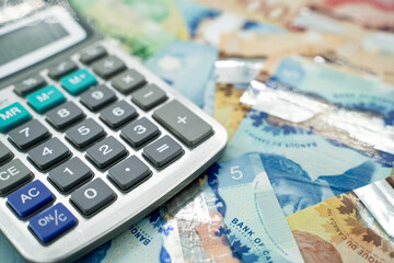Close up of Canadian banknotes with calculator.