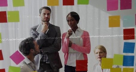 Collaborating professionals in suits planning at glass wall, with sticky notes and overlays