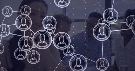 Collaborating professionals reviewing files at conference table in boardroom, with network overlay