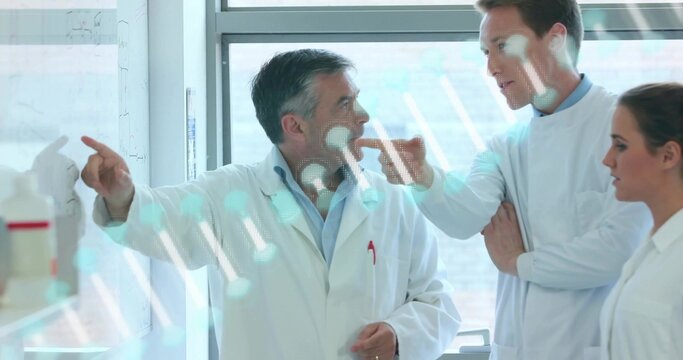 Pointing scientist directing team in lab coats in lab, with whiteboard diagrams and instruments