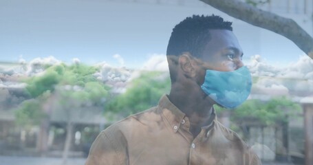 Man wearing tan shirt and blue mask watching cloud reflections in urban courtyard, copy space