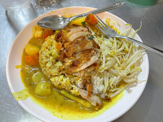 Traditional Thai food made of chicken rice vegetables and green Curry served on a plate