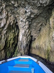 Boat in a cave in the coast on Sicily Italy