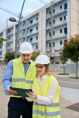 Engineers reviewing building plans on construction site