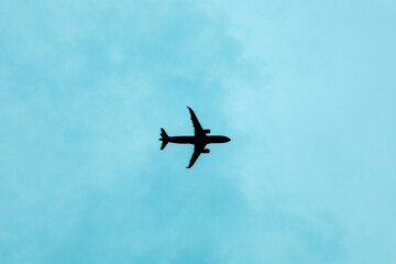Silhouette Commercial Airliner Flying High in the Calm Sky Above