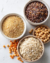 Fototapeta premium bowls filled with quinoa, lentils, chickpeas and oats on light background, minimalistic food layout