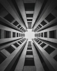 Fototapeta premium Symmetrical worm's-eye view of a brutalist concrete building looking up to the sky