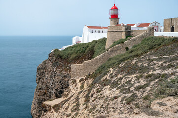 Cape Sao Vincente lighthouse fort on Portuguese coast Algarve End of the World rocky cliffs landscape ocean blue sky travel tourism vacation background copy space
