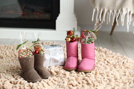 Saint Nicholas day tradition. Boots with sweets, festive decor and gift box on floor indoors